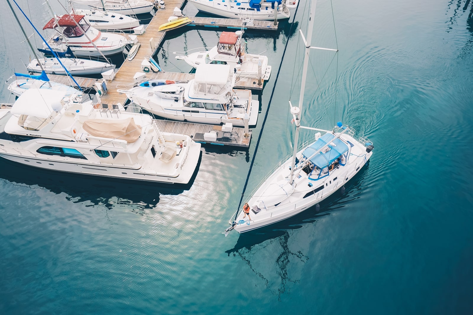 A white boat leaving the marina docks sailing on the water
